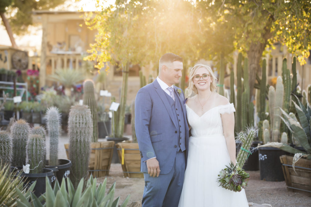 Bride and groom at sunset in front of numerous cacti