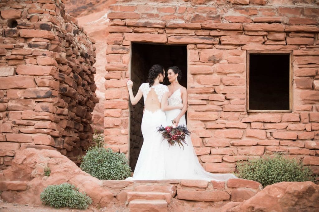 Same sex couple standing in white wedding dresses