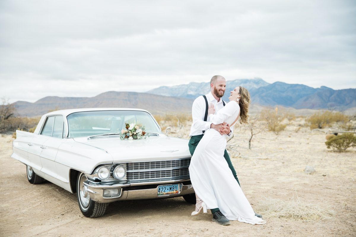 super small wedding ideas bride and groom in desert with vintage car