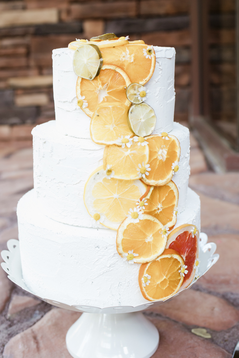 tiered wedding cake with citrus slices and small flowers
