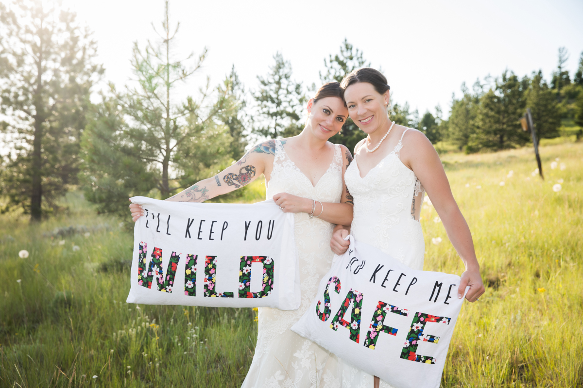 two brides holding pillows that read I'll keep you wild and you keep me safe