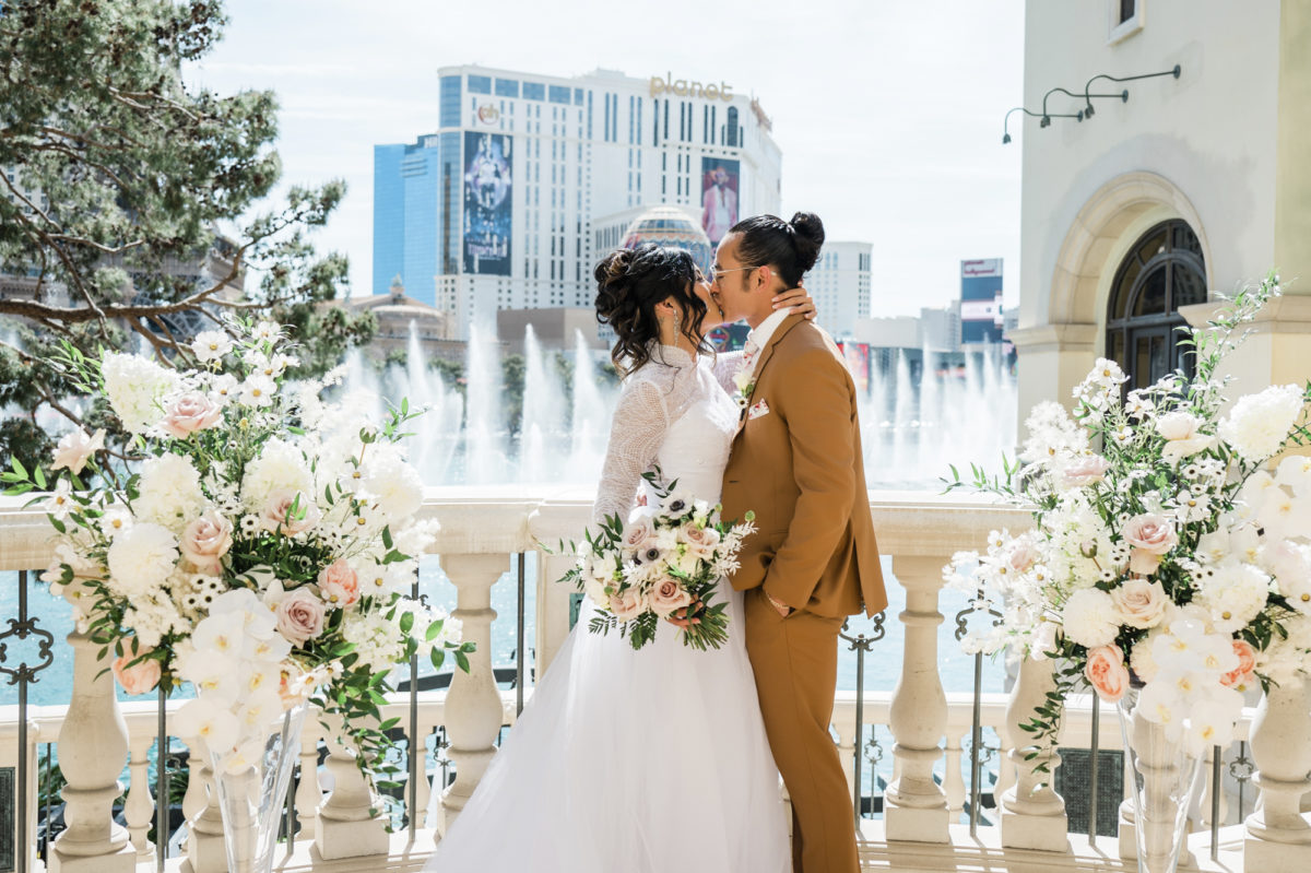 Couple sharing a kiss in front of the famed Bellagio fountains.