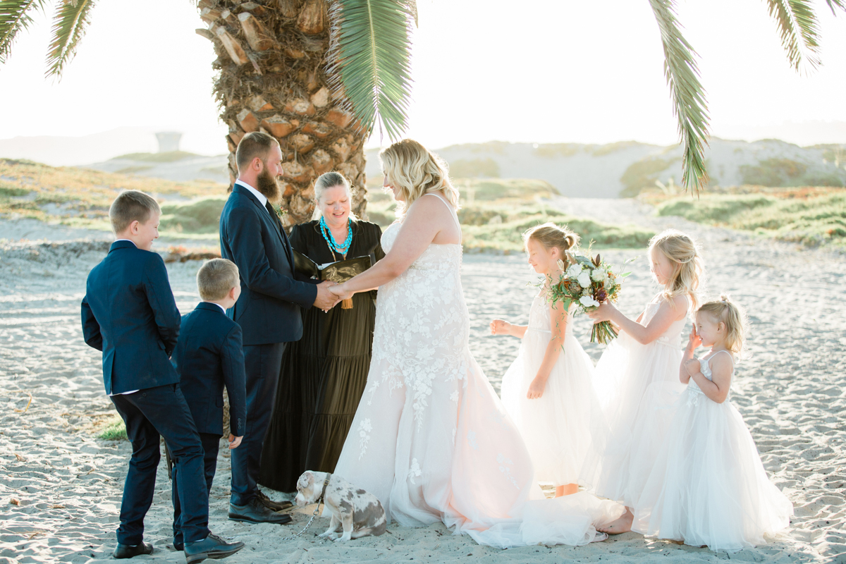 Man and woman at their private wedding at the beach with their five children.